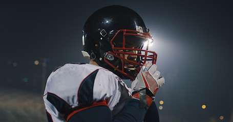 Image showing American Football Player Putting On Helmet on large stadium with