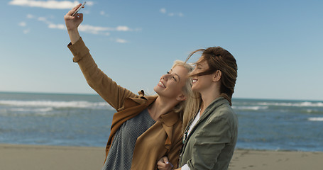 Image showing Girls having time and taking selfie on a beach