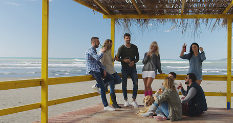 Image showing Group of friends having fun on autumn day at beach