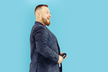 Image showing Young man with microphone on blue background, leading concept