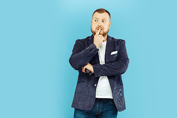 Image showing Young man with microphone on blue background, leading concept