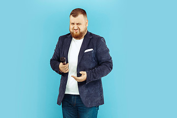 Image showing Young man with microphone on blue background, leading concept