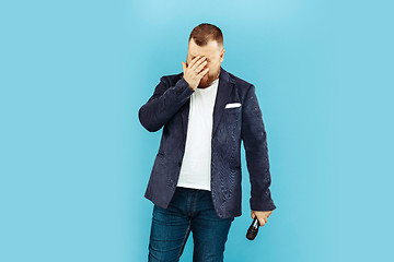 Image showing Young man with microphone on blue background, leading concept