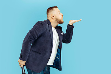 Image showing Young man with microphone on blue background, leading concept