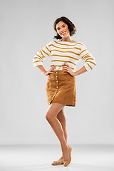 Image showing young woman in striped pullover, skirt and shoes