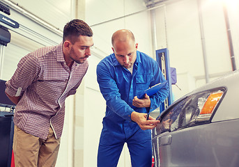 Image showing auto mechanic with clipboard and man at car shop