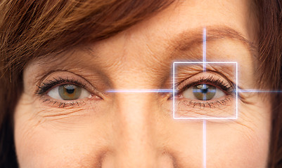 Image showing close up of senior woman eyes with laser light