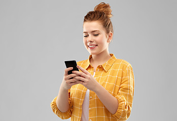 Image showing smiling red haired teenage girl using smartphone