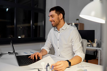 Image showing businessman with laptop working at night office