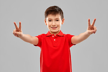 Image showing smiling boy in red t-shirt showing peace gesture