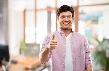 Image showing happy young man showing thumbs up over office room