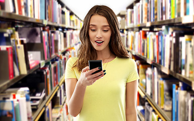 Image showing teenage student girl using smartphone at library