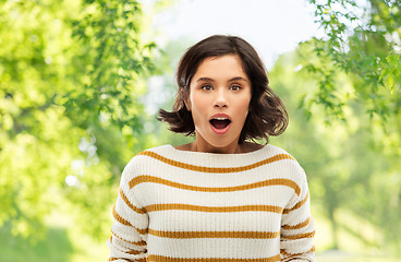 Image showing surprised young woman over natural background