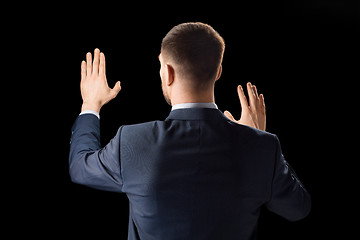 Image showing businessman working with invisible virtual screen