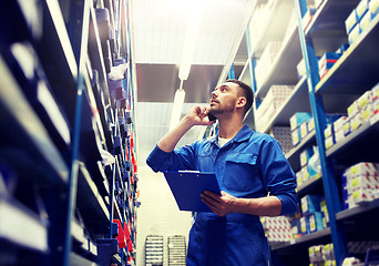 Image showing auto mechanic calling on smartphone at car shop