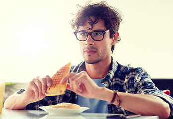 Image showing happy man eating sandwich at cafe for lunch