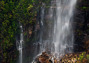 Image showing Waterfall cascading onto a rocky rubble at its cliff base