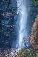 Image showing Waterfall tumbling down onto boulders at its base