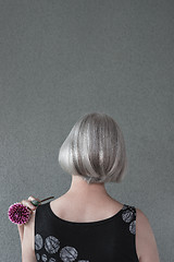 Image showing Lady with silver hair and red dahlia