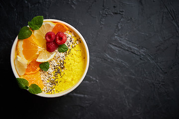 Image showing Tasty orange fresh smoothie or yogurt served in bowl. With raspberries, orange slices, chia seeds