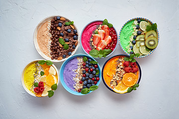 Image showing Various healthy fresh smoothies or yogurts in bowls. With strawberries, kiwi, chia, blackberries