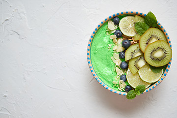 Image showing Green smoothie or yogurt bowl. With fresh kiwi, blueberries, lim