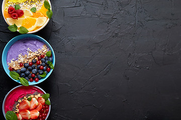 Image showing Various healthy fresh smoothies or yogurts in bowls. With strawberries, kiwi, chia, blackberries