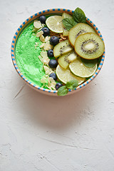 Image showing Green smoothie or yogurt bowl. With fresh kiwi, blueberries, lim