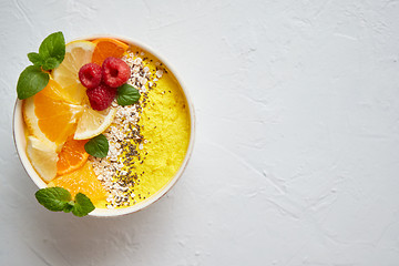 Image showing Tasty orange fresh smoothie or yogurt served in bowl. With raspberries, orange slices, chia seeds