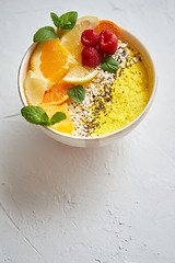 Image showing Tasty orange fresh smoothie or yogurt served in bowl. With raspberries, orange slices, chia seeds