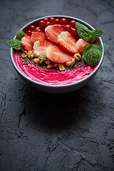 Image showing Summer berry smoothie or yogurt bowl with strawberries, red currants and chia seeds on black