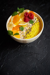 Image showing Tasty orange fresh smoothie or yogurt served in bowl. With raspberries, orange slices, chia seeds