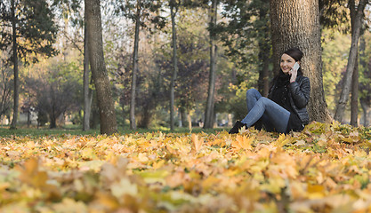 Image showing Woman with a Mobile in a Forest in the Autumn