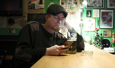 Image showing Guy smokes in the bar