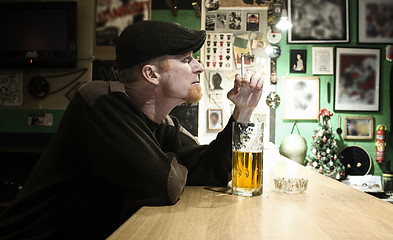 Image showing Guy smokes in the bar