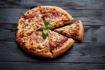 Image showing Sliced pizza Margarita with basil leafs