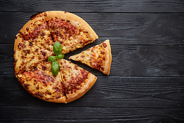 Image showing Sliced pizza Margarita with basil leafs