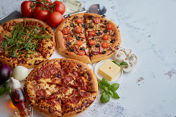 Image showing Three american style pizzas served on a table