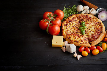 Image showing Delicious italian pizza served on black wooden table