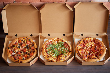 Image showing Three different kind of pizzas in delivery boxes