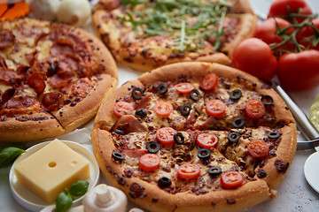 Image showing Three american style pizzas served on a table