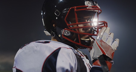 Image showing American Football Player Putting On Helmet on large stadium with