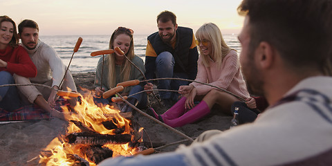 Image showing Group Of Young Friends Sitting By The Fire at beach