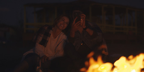 Image showing Couple enjoying bonfire with friends on beach