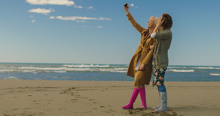 Image showing Girls having time and taking selfie on a beach