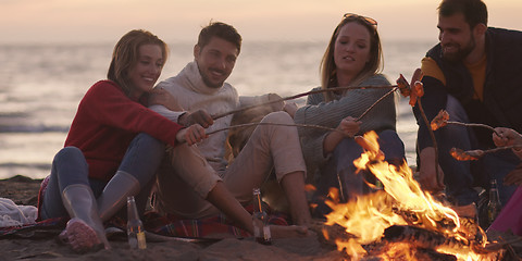 Image showing Group Of Young Friends Sitting By The Fire at beach