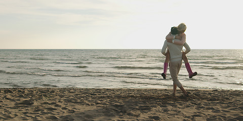 Image showing Loving young couple on a beach at autumn on sunny day