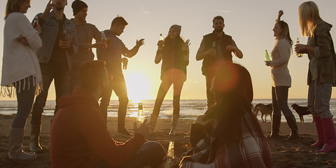 Image showing Friends having fun at beach on autumn day