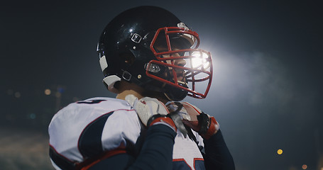 Image showing American Football Player Putting On Helmet on large stadium with