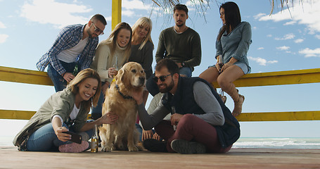 Image showing Group of friends having fun on autumn day at beach